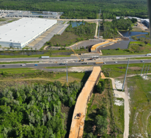 Vi ayeryen pasaj pou bèt sovaj yo an konstriksyon sou gran wout Interstate 4 nan konte Polk, Florid, ki montre trepye, ekipman konstriksyon, ak ranblè y ap konstwi atravè gran wout la, ak trafik k ap deplase anba ak marekaj ak espas vèt ouvè ki antoure sit la.